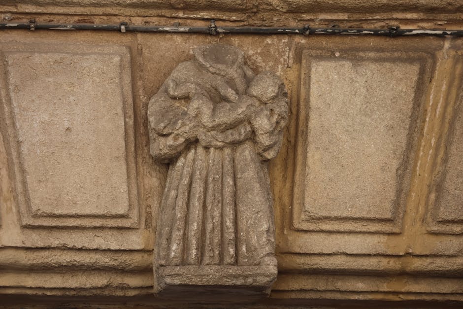 Stone carving of a woman with a child on a historic lintel in El Puerto de Santa María.